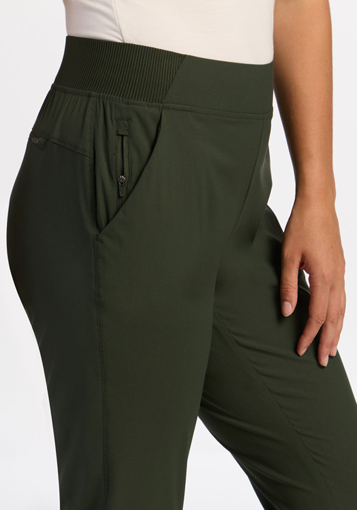 Model wears Woolx Palmer Joggers in Duffel Bag, featuring a zip side pocket and elastic high waistband, white top showing.