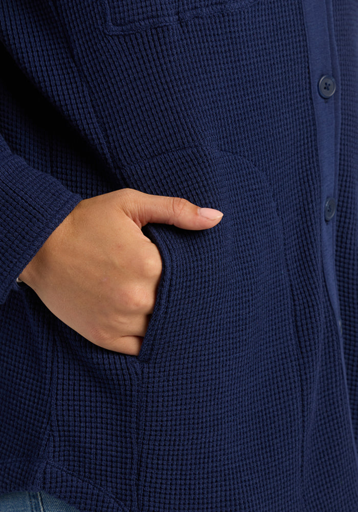 A hand rests in the pocket of the Woolx Oaklynn Waffle Shacket in Ocean Cavern.
