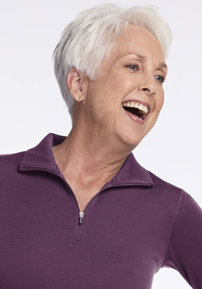 Smiling older woman in Woolx Brooke 1/4 Zip - Purple Iris shows off stylish, temperature-regulating Merino comfort.