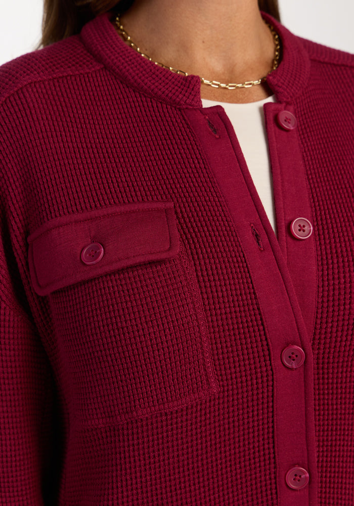 Close-up of a woman in the Woolx Oaklynn Waffle Shacket in Beet Red, styled with a gold chain necklace.