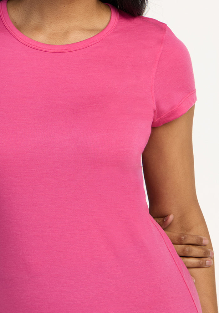 A woman models the Woolx Addie Short Sleeve Crew in Raspberry Fizz, a lightweight, odor-free Merino wool tee shown from shoulders to midsection against a plain background—ideal for all-day comfort.
