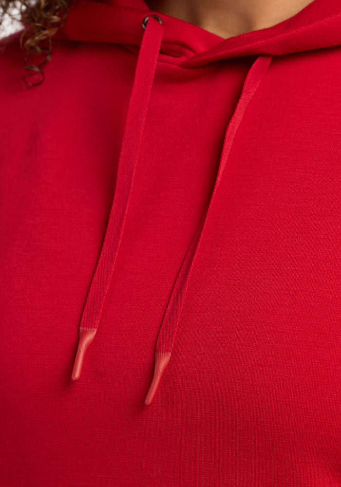 Close-up of the Woolx Avery Hoodie - Maraschino Cherry, showcasing cozy red fabric, drawstrings, and neckline detail.