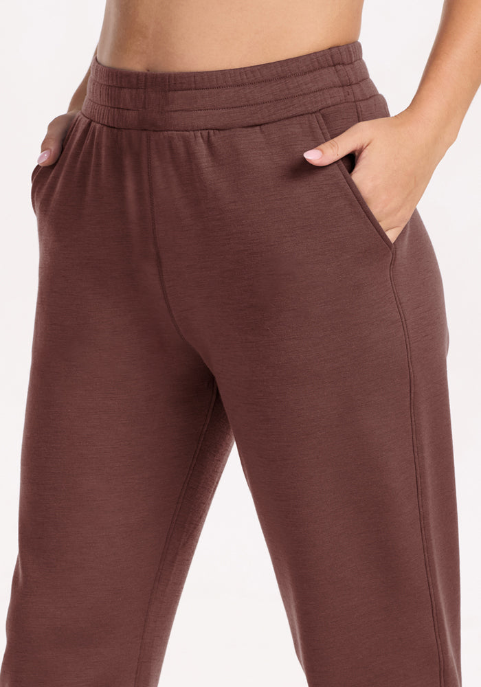 Model wears Woolx Parker Sweatpants in Canyon Clay, hands in pockets, shown waist to mid-thigh against plain background.