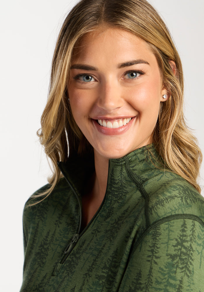 Smiling woman in a Woolx Emi 1/4 Zip – Forest Friends, standing against a plain white background.