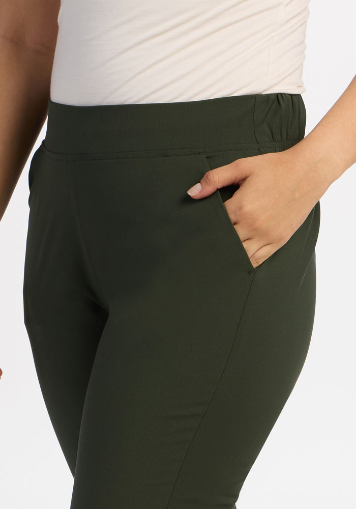 A person in Woolx Nicole Ankle Pants - Duffel Bag, odor-resistant merino wool, tapered fit, hand in pocket, waist-mid thigh.