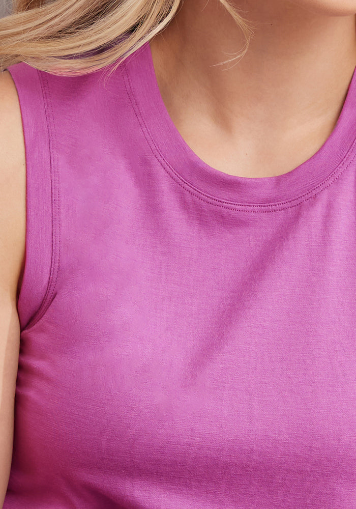 Close-up of a person wearing the Woolx Bella Tunic Top in Purple Wine, showcasing the lightweight merino fabric and rich color. Only part of their neck, shoulder, and hair is visible, with focus on the shirt’s texture.