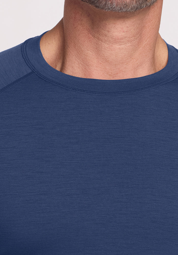 Close-up of a person wearing the Woolx Essential Tee - Starry Night. Only the lower face, neck, and upper chest are visible against a plain, light background.