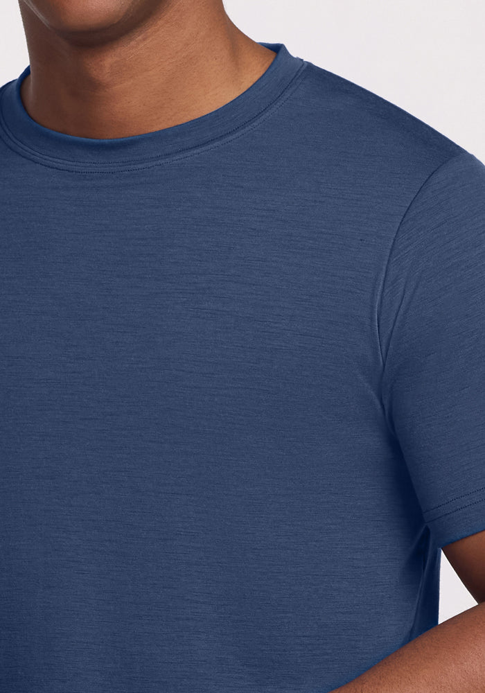 A close-up of a person wearing the Woolx Endurance Tee - Starry Night, showing only the lower half of their face and upper torso against a light background.