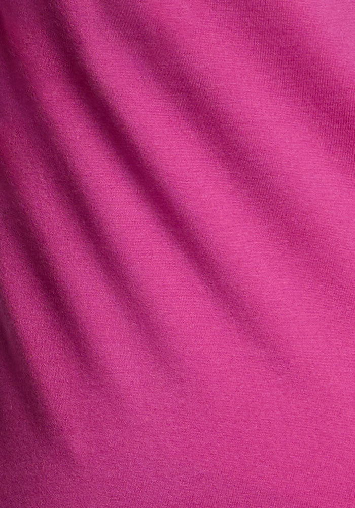 Close-up of Woolx Clara Dress - Summer Sorbet, textured pink Merino wool with horizontal folds and soft shadows.