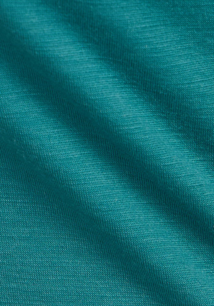Close-up of the teal fabric from the Woolx Liza Crew Neck Tee - Surfside shows the lightweight Merino wool’s visible weave, gentle folds, and smooth, slightly stretchy texture—ideal for performance and comfort.