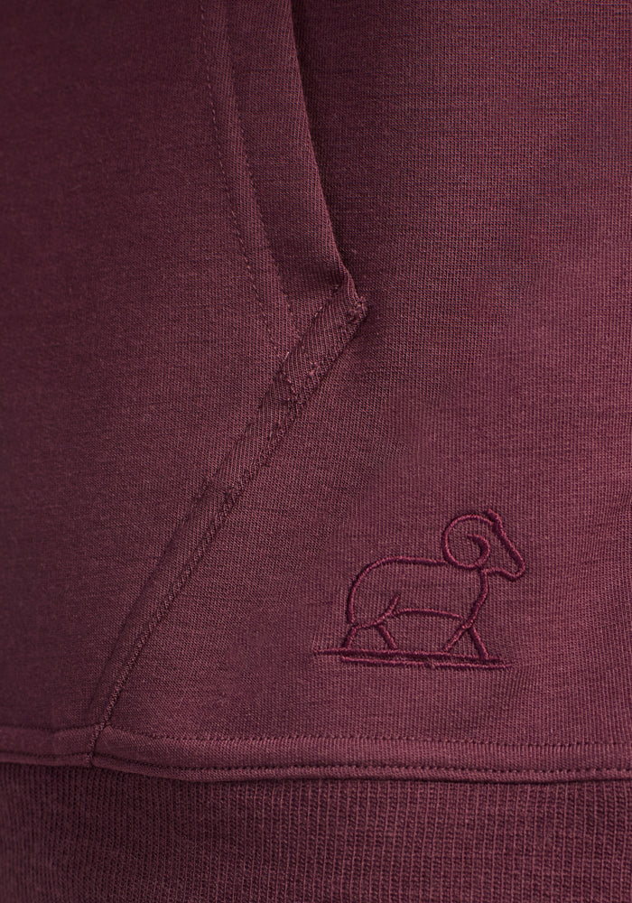 Close-up of the Woolx Chase Hoodie in Grape Harvest, featuring visible stitching and an embroidered ram outline near the pocket.