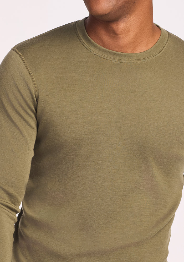 A close-up of a man wearing the Woolx Explorer Base Layer in Winter Moss, designed to keep him comfortable and dry.
