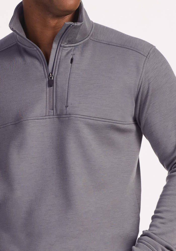 A man wears the Woolx Mason 1/4 Zip in Arctic Dusk, a light gray Merino wool fleece pullover with a chest pocket, shown from shoulders to waist against a plain background. His face is mostly out of frame.