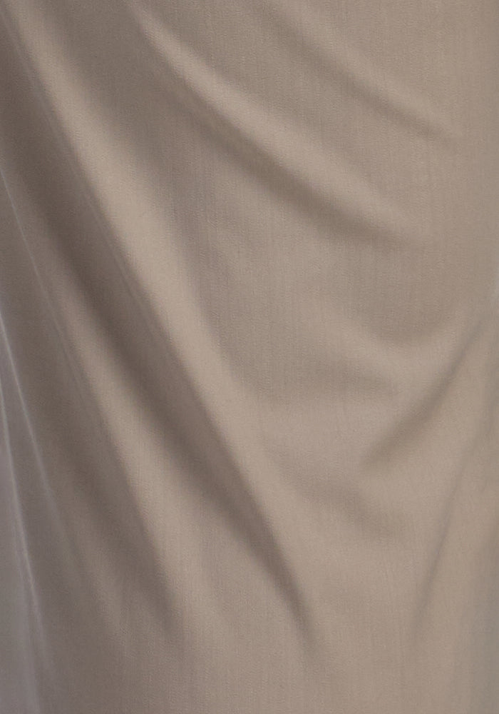 Close-up of Vintage Khaki Nicole Tall Ankle Pant by Woolx, showing the beige fabric's folds and creases that highlight the texture and natural drape of these moisture-wicking, tapered-leg pants.