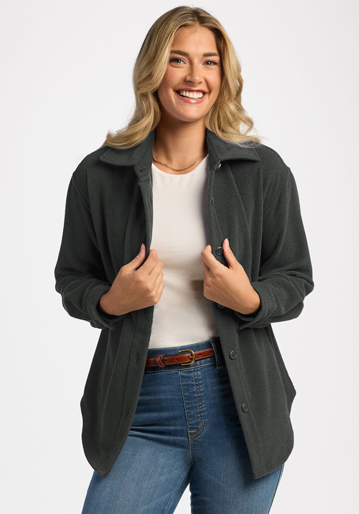 Smiling woman in Woolx Jovie Shacket - Volcanic Ash and jeans stands forward, showing off this warm layer. 