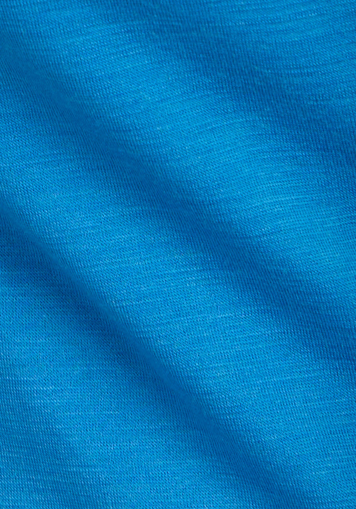 Close-up of bright blue, moisture-wicking fabric with visible texture and soft surface, highlighting the weave of the Woolx Junie V Neck - Wave Rider women’s relaxed fit Merino wool tee.