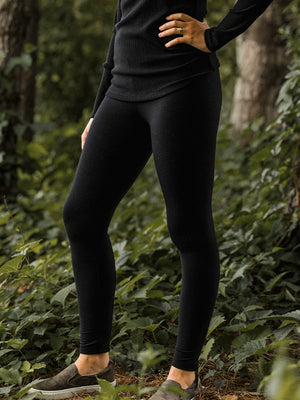 Model wearing black Woolx legggins in woods