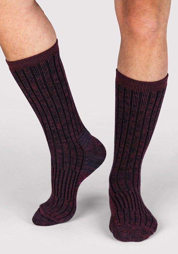 A person wears Woolx Mens Joey Crew Socks in Warm Violet, standing on a light background with one foot slightly ahead and knees visible.