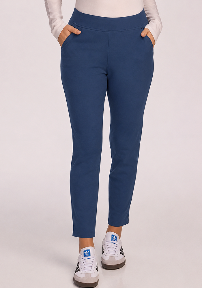 Person wearing Woolx Nicole Petite Ankle Pant in Vintage Indigo, white long-sleeve top, and white sneakers with blue accents.