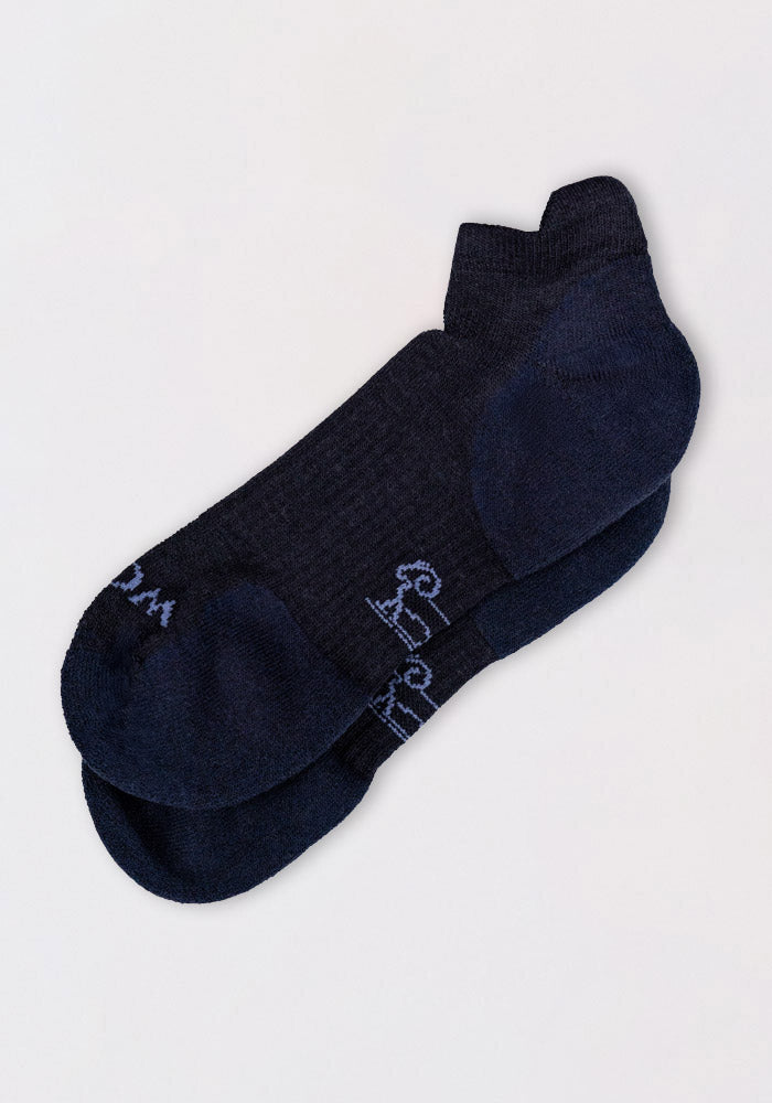 The Woolx Womens Rowan No Show Socks in Deep Night are dark navy Merino wool ankle socks with a ribbed texture, cushioned comfort, and subtle branding near the toe, shown laid flat on a light background.