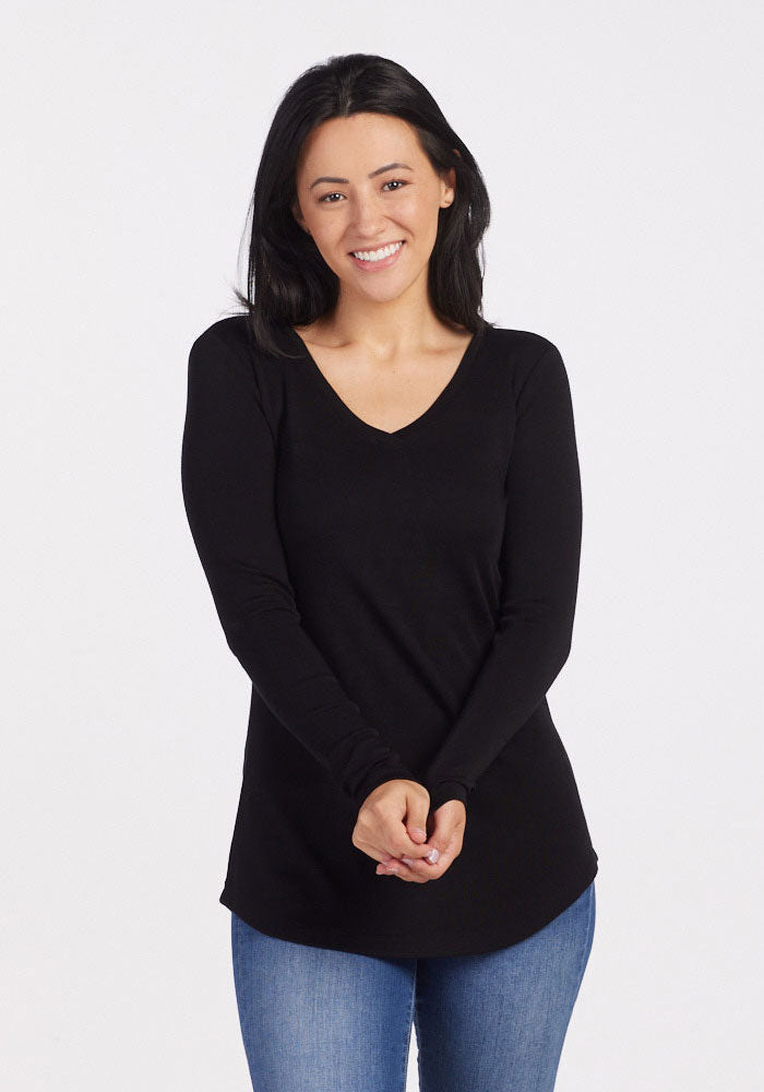 Woman in the Woolx Eva Petite Tunic - Black and blue jeans smiles against a plain white background.