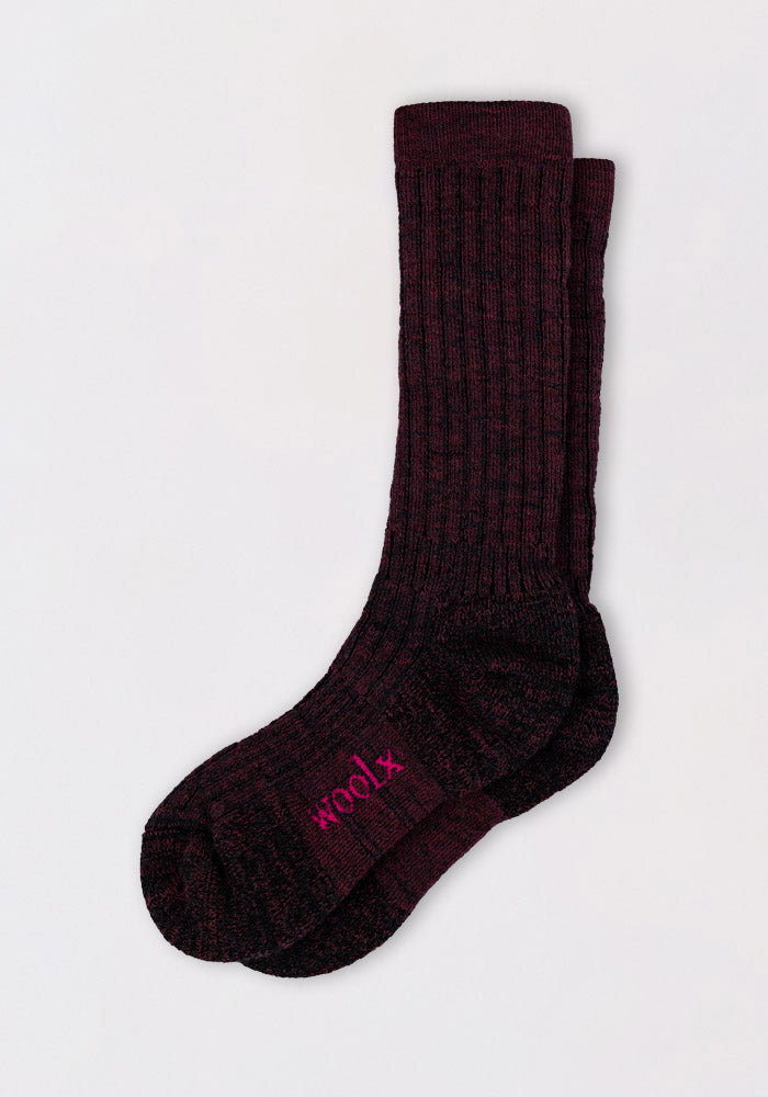 A pair of Woolx Womens Joey Mid Calf Socks in warm violet, featuring ribbed texture and "×100%" in bright pink on the sole, are shown with one sock laid flat over the other.