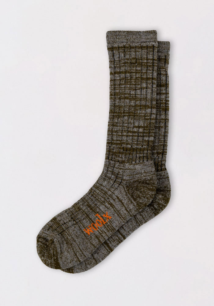 The Woolx Womens Joey Mid Calf Socks in Dark Forest Marled feature a grayish-green ribbed design with "work" embroidered in orange on the sole, shown against a light background.