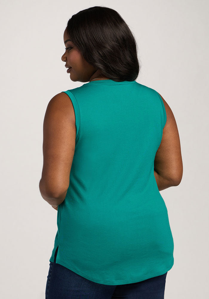 Woman with dark hair wears Woolx Bella Tunic Top - Cabana Crush and dark jeans, shown from the back on plain background.