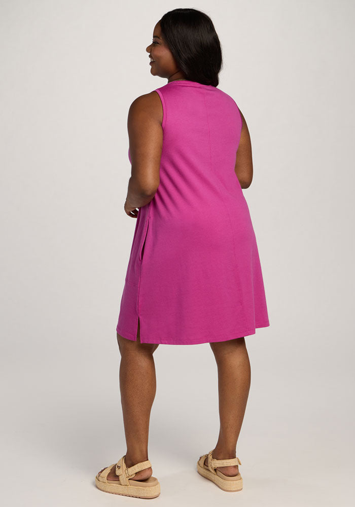 A woman in the Woolx Clara Dress - Summer Sorbet and sandals stands facing away against a plain background.