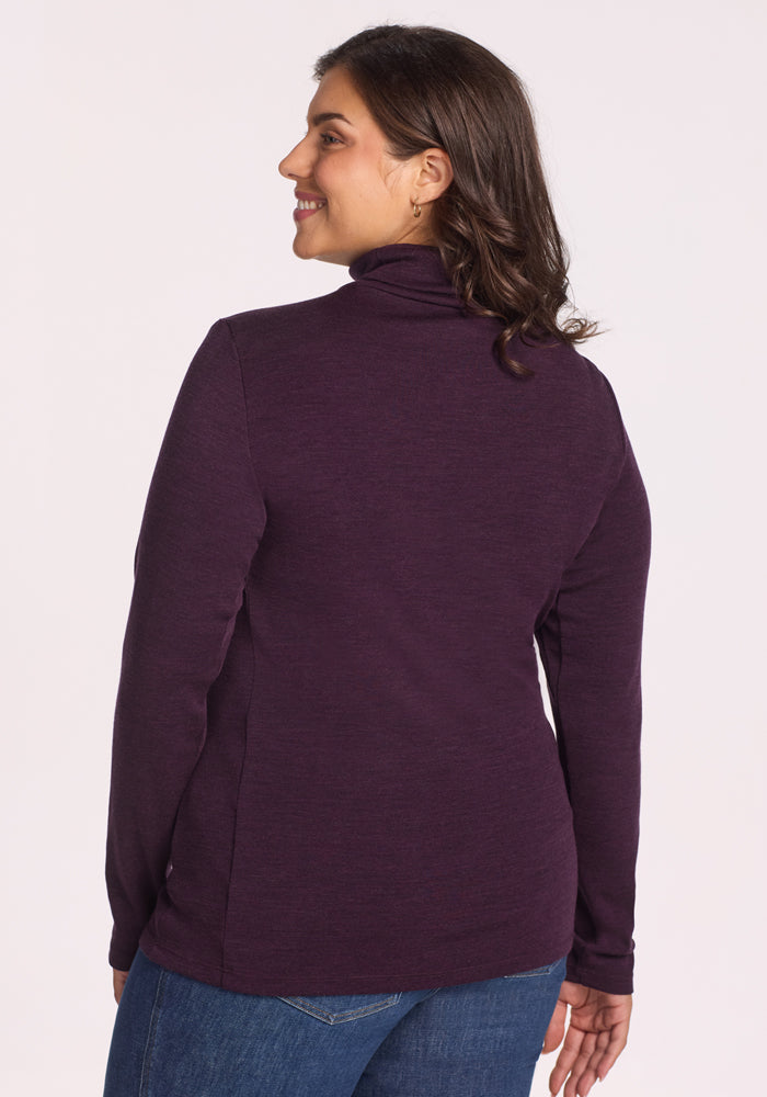 A woman in the Woolx Peyton Turtleneck sweater in Deep Plum.