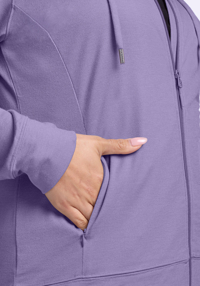 A close-up of a person wearing the Woolx Ryann Hoodie in Montana Grape, with their left hand partially inside the front pocket. The lightweight hoodie features a visible seam and drawstrings.