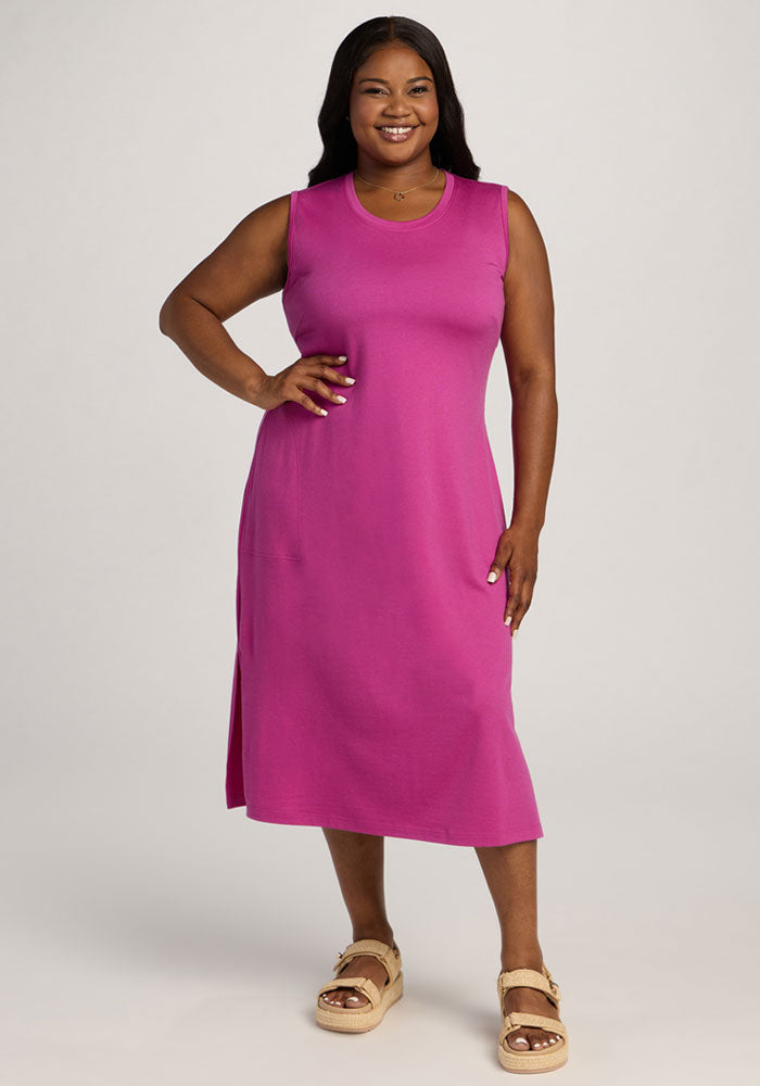 Smiling woman in the Woolx Cassie Dress - Summer Sorbet, sleeveless and knee-length, poses against a light background. 