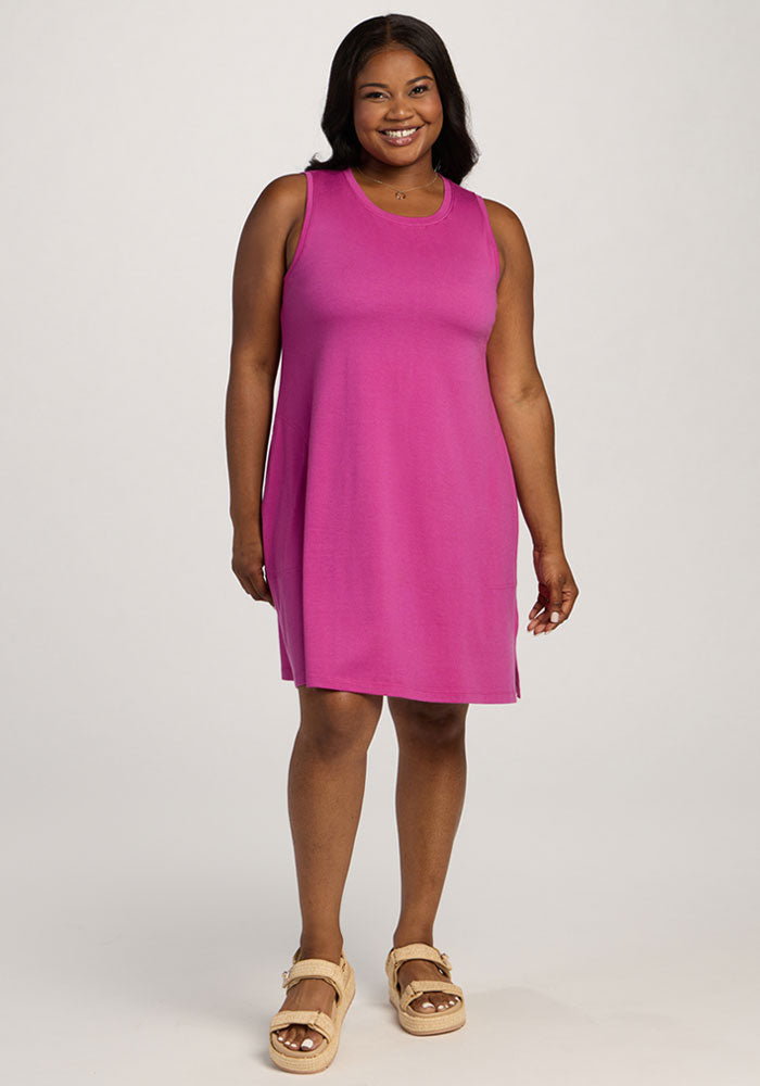 Woman in Woolx Clara Dress - Summer Sorbet, smiling in beige sandals against a plain white background. 