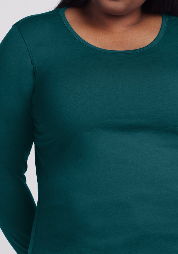 A person wearing the Woolx Remi Long Sleeve T-Shirt in Riverbank Green. The image is cropped to show the upper torso and part of the neck, with no face visible.