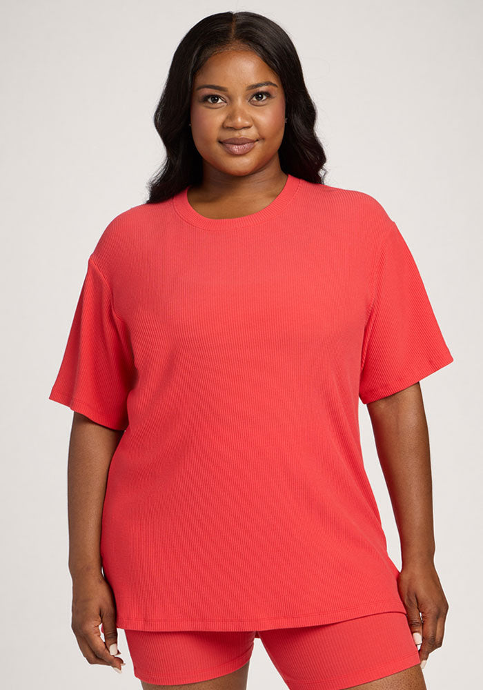 Woman in the Woolx Vera Ribbed Tunic - Hibiscus and matching shorts, standing against a plain background. 