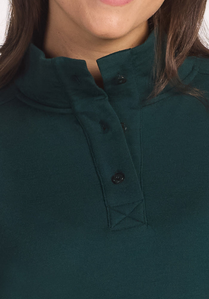 Close-up of a person wearing the Woolx Annie 3 Button Pullover in Deep Timber. Only the lower half of the face, part of a smile, and brown hair are visible.