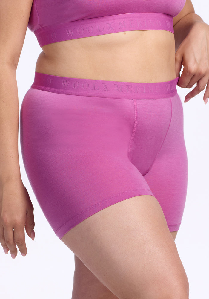 A person wears Woolx's Elliott Boyshort in Wild Blossom—matching antimicrobial pink underwear—showcasing the midsection and upper thighs against a plain white background.