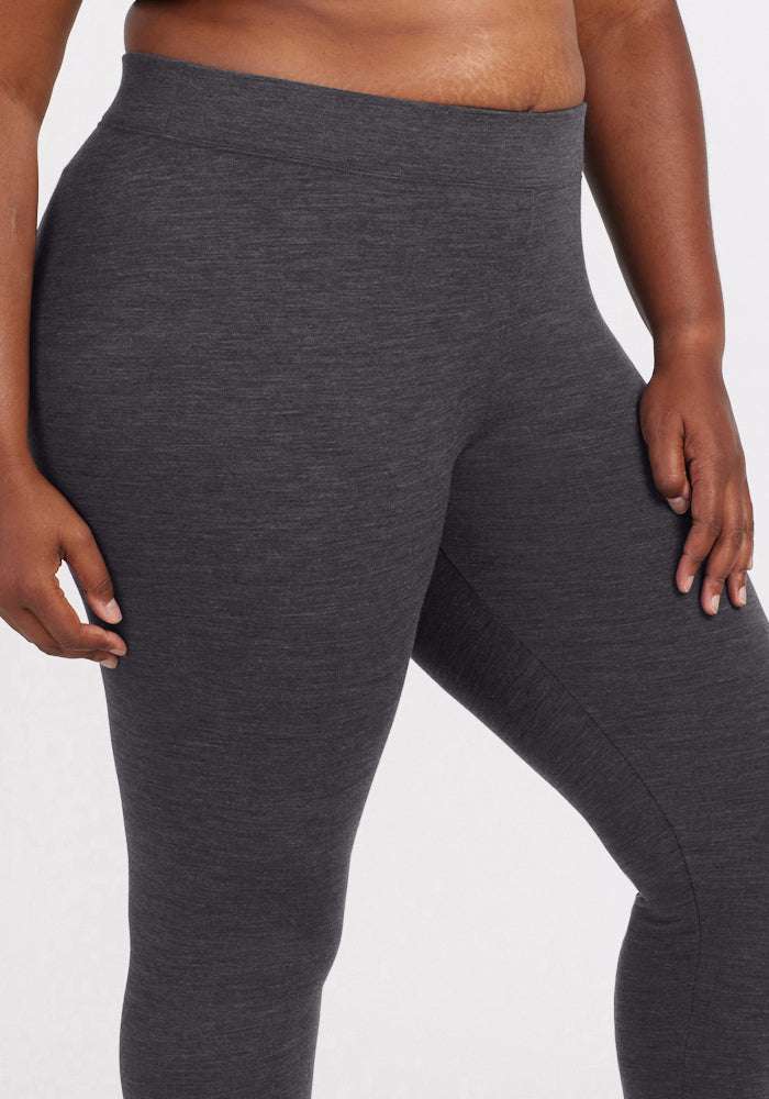 A person models the Woolx Stella Leggings in Cinder Melange, with only the lower torso and upper legs visible against a white backdrop, highlighting these high-waisted Merino wool winter leggings.