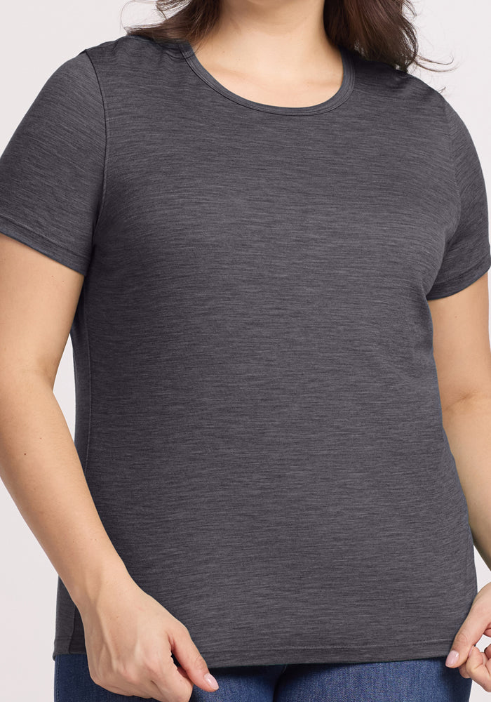 A person wearing the Woolx Liza Crew Neck Tee in Cinder Melange and blue jeans, shown from shoulders to hips against a neutral background.