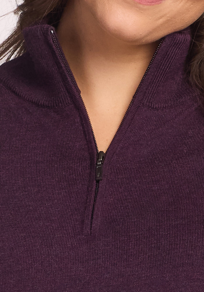 Close-up of a person wearing the Woolx Collins Half Zip Sweater in Deep Plum, featuring ribbed merino wool texture and partially unzipped to reveal their neck and lower face.
