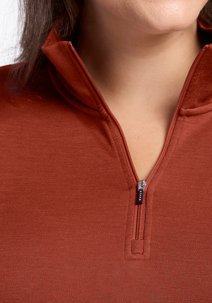 Close-up of a person wearing the Woolx Brooke 1/4 Zip in Maple Leaf, with the zipper partially open to highlight the Merino wool’s texture and the quality zipper details at the collar and upper chest.