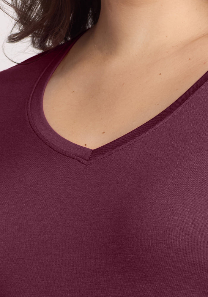 Close-up of a person wearing the Woolx Millie Long Sleeve in Grape Harvest, highlighting the V-neckline and upper chest area against a light background.