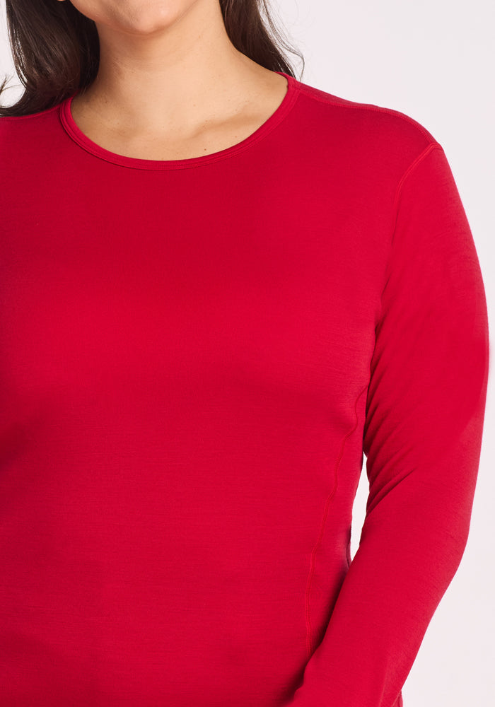 A person wears the Woolx Hannah Long Sleeve Top in Maraschino Cherry, shown from shoulders to waist against a plain light background.